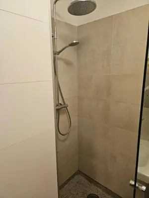 a shower with a glass door in a bathroom at The Amsterdam - South Apartment in Amsterdam