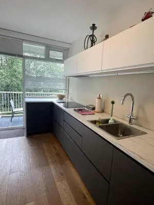 a kitchen with a sink and a large window at The Amsterdam - South Apartment in Amsterdam