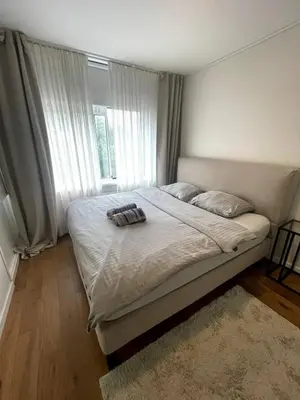 a bedroom with a large bed with a window at The Amsterdam - South Apartment in Amsterdam