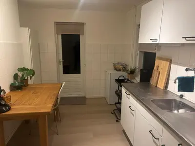 a kitchen with a table and a sink in it at Have a nice stay! - Ruim appartement de Molen in Noordwijk