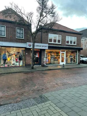 a store on a street with a tree in front of it at Have a nice stay! - Ruim appartement de Molen in Noordwijk