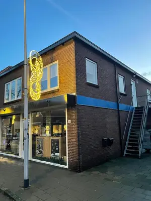 a store with a large yellow sign on the side of a building at Have a nice stay! - Ruim appartement de Molen in Noordwijk