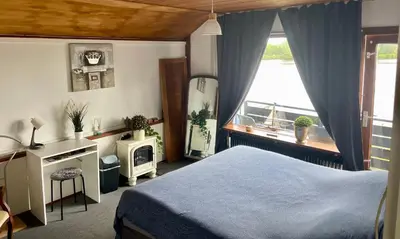 a bedroom with a bed and a window at 1-2 pp ROOM AMS Airport great view lake in Roelofarendsveen