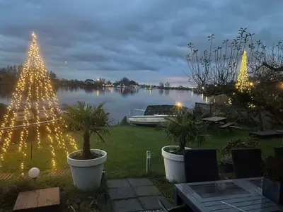 a christmas tree with lights on a lake at 1-2 pp ROOM AMS Airport great view lake in Roelofarendsveen
