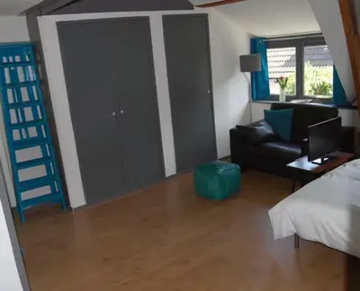 a bedroom with a bed and a couch and a chair at Apartement with terras in Amsterdam Noord in Amsterdam