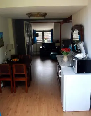 a living room with a kitchen and a living room with a microwave at Apartement with terras in Amsterdam Noord in Amsterdam