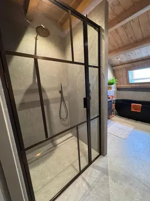 a glass door with a shower in a room at 't Voorhuys Noordwijk aan Zee- tuin en gratis parkeren in Noordwijk