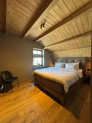a bedroom with a bed and a wooden ceiling at 't Voorhuys Noordwijk aan Zee- tuin en gratis parkeren in Noordwijk