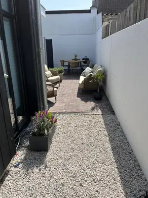 a patio with chairs and flowers on a patio at 't Voorhuys Noordwijk aan Zee- tuin en gratis parkeren in Noordwijk