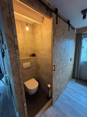 a bathroom with a toilet and a shower at BeachBreak Guesthouse in Noordwijk