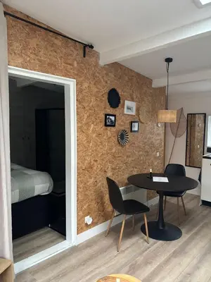a room with a table and chairs and a bed at BeachBreak Guesthouse in Noordwijk