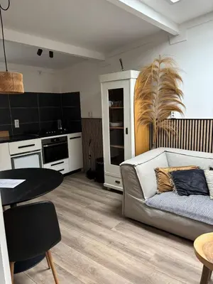 a living room with a couch and a table at BeachBreak Guesthouse in Noordwijk