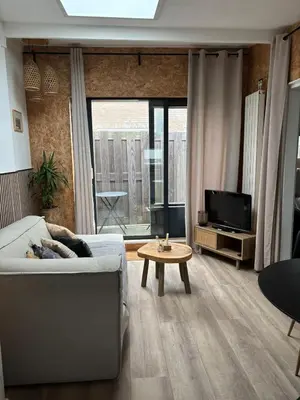 a living room with a couch and a tv at BeachBreak Guesthouse in Noordwijk