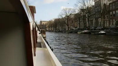 a boat is traveling down a canal with buildings at Prinsenboot in Amsterdam