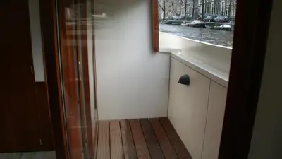 a small room with a window and a wooden floor at Prinsenboot in Amsterdam