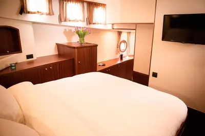 a bedroom with a white bed and a television at Prinsenboot in Amsterdam