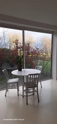 a table and two chairs in a room with a window at gastenverblijf Bij de Dijk in Warmenhuizen