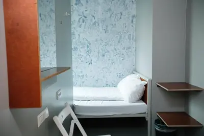 a small room with a small bed and a chair at ClinkNOORD Hostel in Amsterdam