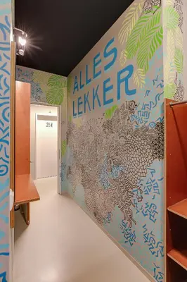 a hallway with a wall covered in graffiti at ClinkNOORD Hostel in Amsterdam