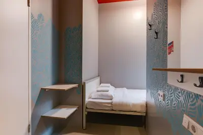 a small room with a small bed and a closet at ClinkNOORD Hostel in Amsterdam
