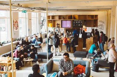 a crowd of people sitting in a waiting room at ClinkNOORD Hostel in Amsterdam