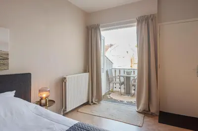 a bedroom with a bed and a view of a balcony at Boutique Pension Bennekom - Studio's & Apartment in Zandvoort
