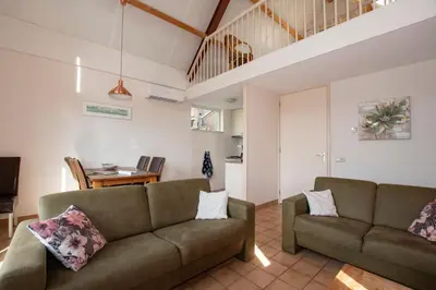 a living room with two couches and a table at Zaanse Rietveld Logies in Alphen aan den Rijn