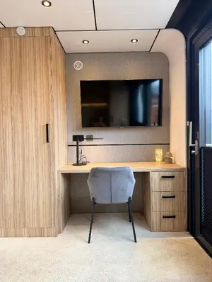 a desk with a television and a chair in a room at Villa Perla Mare - Sauna Experience - On a lake near Amsterdam in Vinkeveen