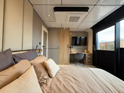a bedroom with a bed and a desk in it at Villa Perla Mare - Sauna Experience - On a lake near Amsterdam in Vinkeveen