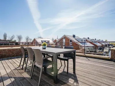 a table and chairs on top of a deck at Oostergeest in Uitgeest