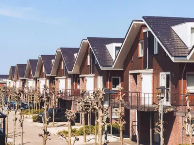 a row of houses with trees in a parking lot at Oostergeest in Uitgeest