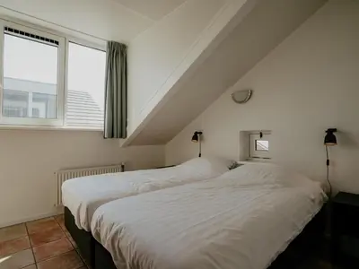 two beds in a room with a window at Oostergeest in Uitgeest