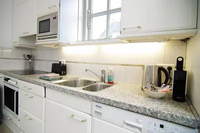 a kitchen counter with a sink and a microwave at spacious new appartment in Lisse
