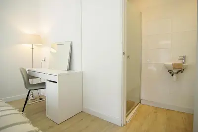 a white room with a desk and a mirror at spacious new appartment in Lisse