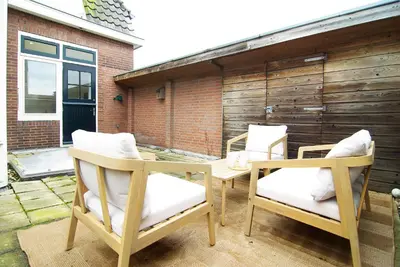 two chairs and a table on a patio at spacious new appartment in Lisse