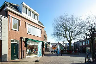 a city street with a brick building and a store at spacious new appartment in Lisse