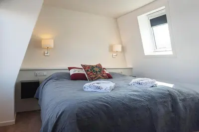 a bedroom with a bed with two pillows on it at Garden House Harry in Zandvoort