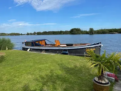 a boat is docked on the shore of a lake at 1-2 P Room near Airport AMS freeparking in Roelofarendsveen