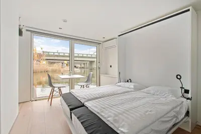 a bedroom with a bed and a table and chairs at HouseBoat the New Lake - Nieuwe Meer in Amsterdam