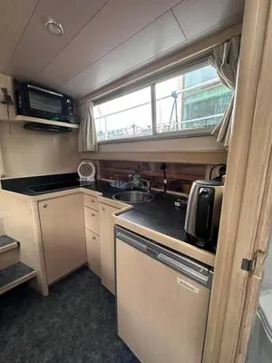 a kitchen in an rv with a sink and a microwave at Luxury Houseboat in Amsterdam