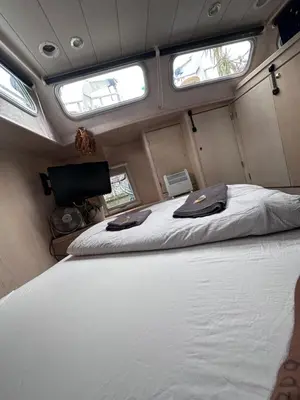 a bed in the middle of a room with two windows at Luxury Houseboat in Amsterdam