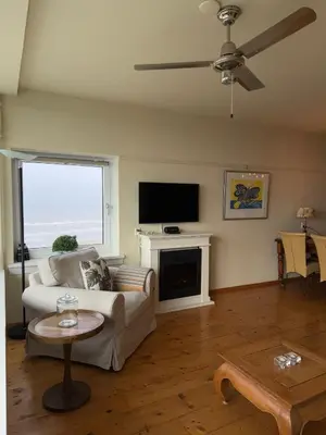 a living room with a couch and a tv at Blue Bay Zandvoort in Zandvoort