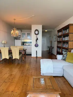 a living room with a white couch and a table at Blue Bay Zandvoort in Zandvoort