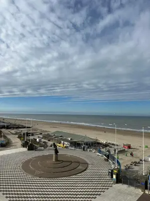 a view of a beach with a statue and the ocean at Blue Bay Zandvoort in Zandvoort