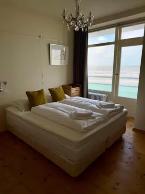 a bedroom with a bed with a view of the ocean at Blue Bay Zandvoort in Zandvoort