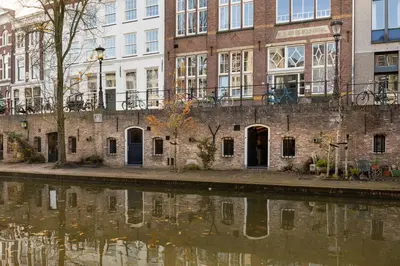 a brick building next to a body of water at Beautiful canal apartment in Utrecht for 4 persons in Utrecht