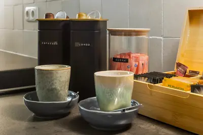 two cups sitting on a counter next to a container at Beautiful canal apartment in Utrecht for 4 persons in Utrecht