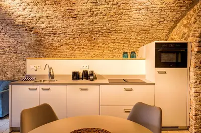 a kitchen with white cabinets and a brick wall at Luxurious canal apartment in Utrecht A Location in Utrecht