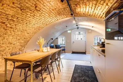 a dining room with a table and a brick wall at 2 Luxurious canal apartments in Utrecht in Utrecht