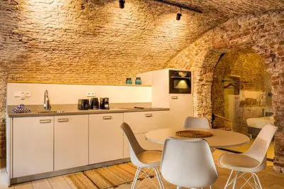 a kitchen with white cabinets and a table and chairs at 2 Luxurious canal apartments in Utrecht in Utrecht